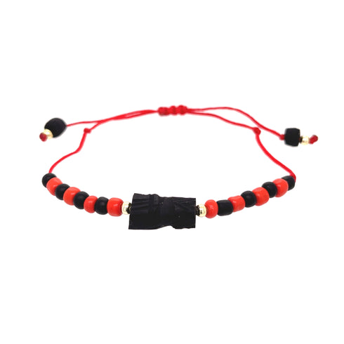The Genuine Azabache Fist Red Rope Evil Eye Bracelet offers both style and protection, showcasing alternating black and red beads alongside a carved black centerpiece on a red adjustable cord.